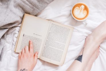Woman reading a book with a cup of coffee